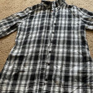 a black and white flannel, button up, and collared.